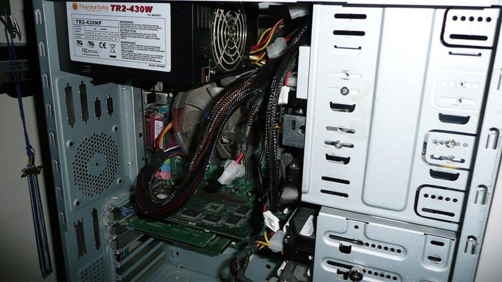 Instalação típica de uma fonte ATX em gabinete de computador, modelo Thermaltake TR2-430NW.