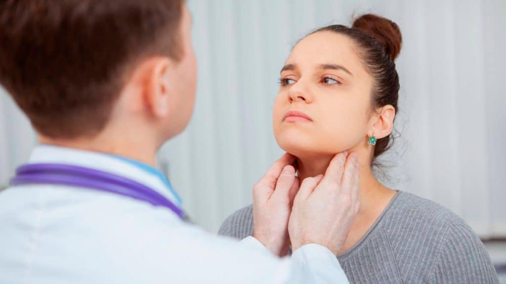 Médico examinando amígdalas de uma mulher