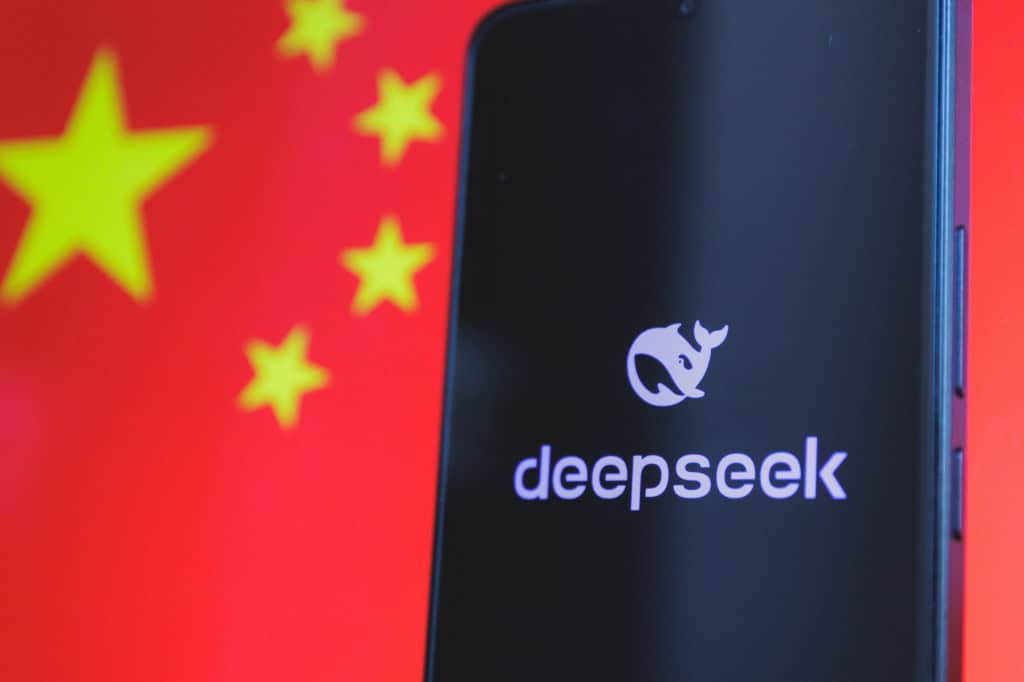 Ao fundo, bandeira da China; à frente, logo da DeepSeek em um smartphone