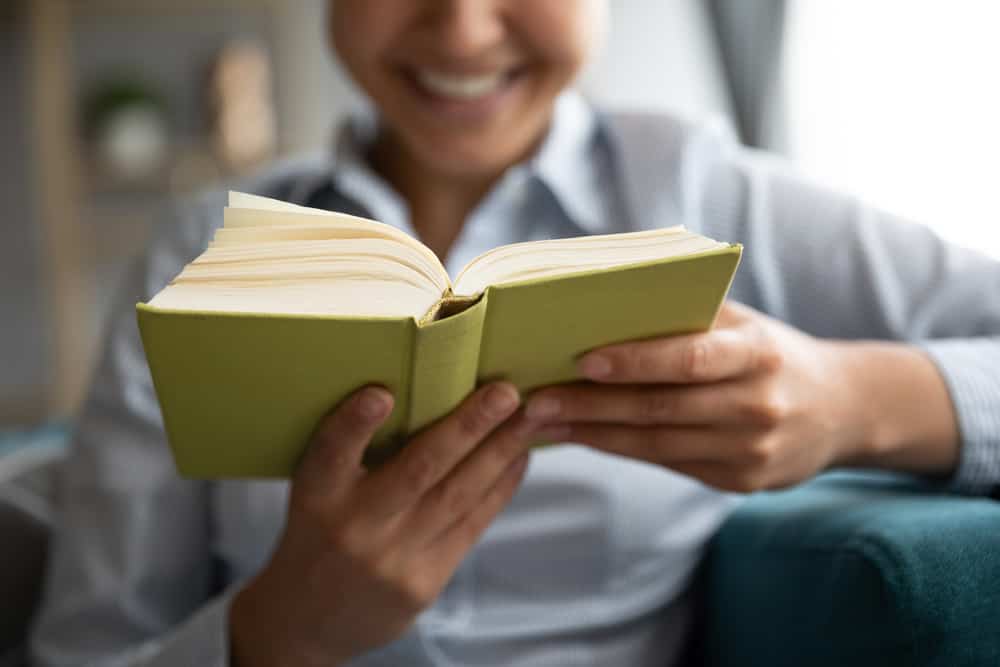 Mulher segurando e lendo um livro